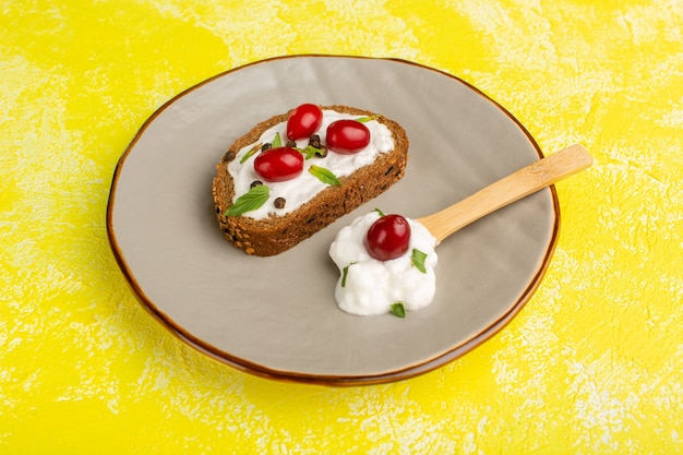 Sabrosas tostadas de pan con crema agria y cornejos dentro de la placa verde sobre amarillo