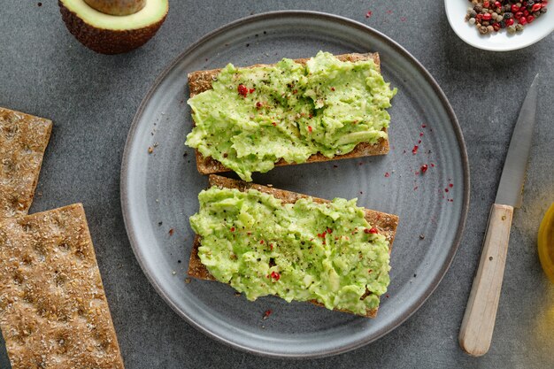 Sabroso apetitoso pan crujiente con puré de aguacate servido en un plato.