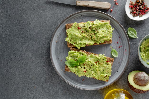 Sabroso apetitoso pan crujiente con puré de aguacate servido en un plato.