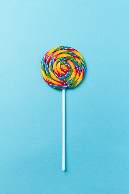 Sabroso apetitoso partido accesorio Sweet Swirl Candy Lollypop sobre fondo azul Vista superior