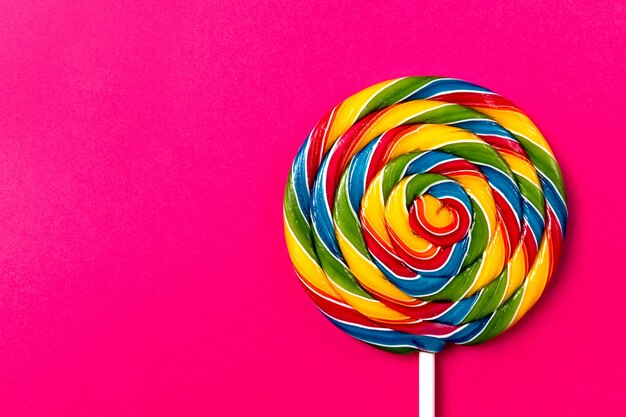Sabroso apetitoso partido accesorio Sweet Swirl Candy Lollypop sobre fondo rosa Vista superior