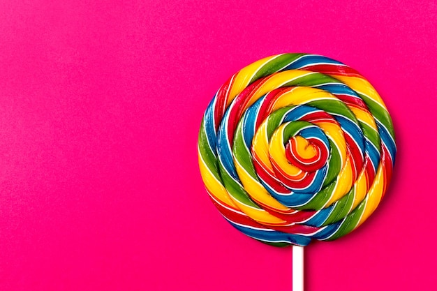 Sabroso apetitoso partido accesorio Sweet Swirl Candy Lollypop sobre fondo rosa Vista superior