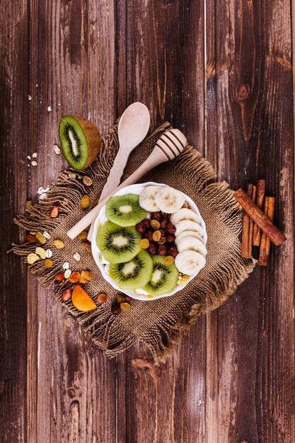 Sabroso desayuno saludable por la mañana hecho de leche y gachas de avena con nueces, kiwis y miel