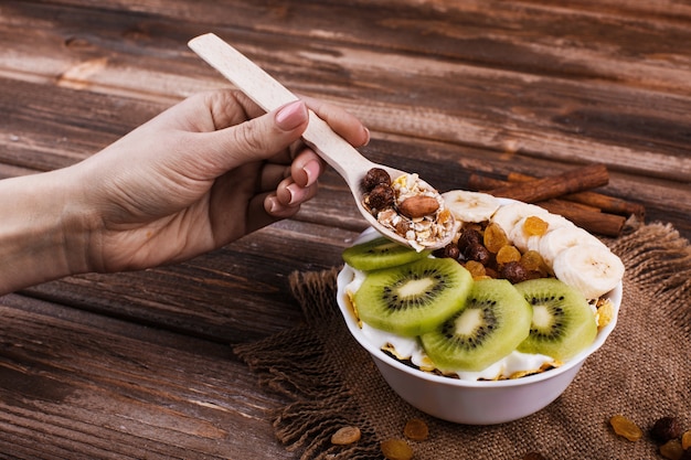 Sabroso desayuno saludable por la mañana hecho de leche y gachas de avena con nueces, kiwis y miel