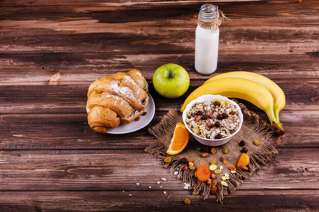 Sabroso desayuno saludable por la mañana hecho de leche y gachas con nueces, manzanas y plátanos