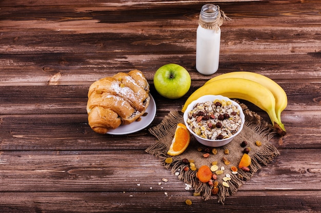 Sabroso desayuno saludable por la mañana hecho de leche y gachas con nueces, manzanas y plátanos
