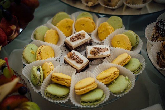 Foto gratuita sabroso macarrón verde y amarillo en la placa de vidrio