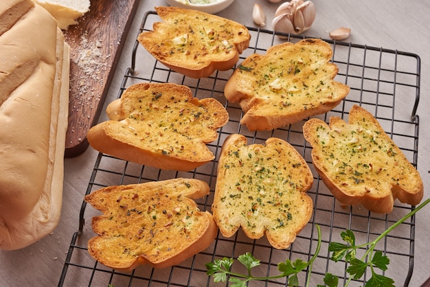Sabroso pan casero con ajo, queso y hierbas en la mesa de la cocina.