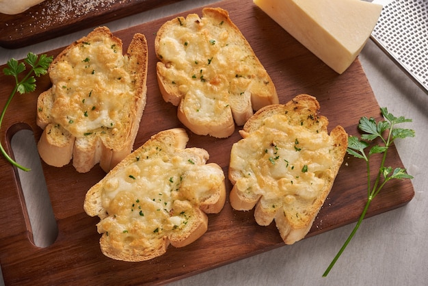 Sabroso pan casero con ajo, queso y hierbas en la mesa de la cocina.