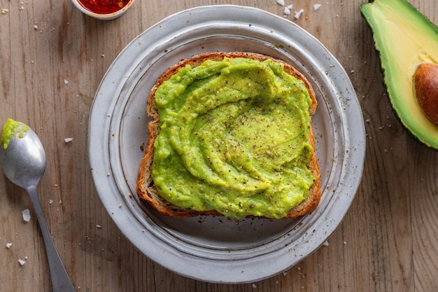 Sabroso pan de sándwich apetitoso con puré de aguacate servido en un plato