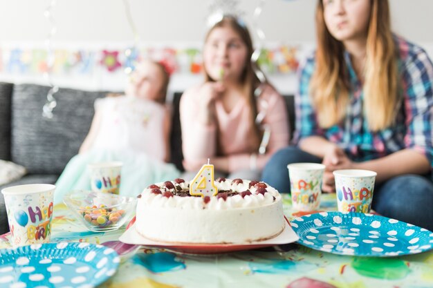 Sabroso pastel cerca de los invitados en la fiesta de cumpleaños