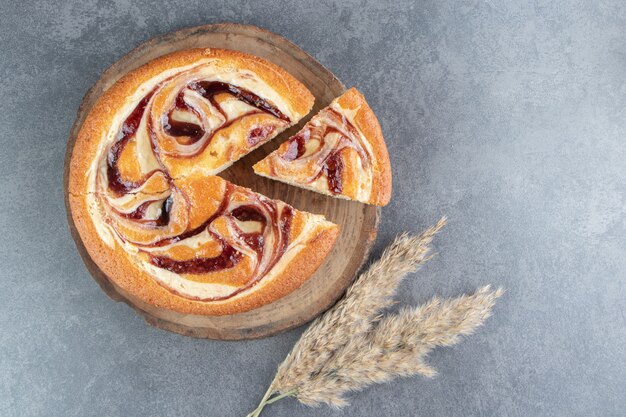 Sabroso pastel de frutas con trigo sobre una tabla de madera