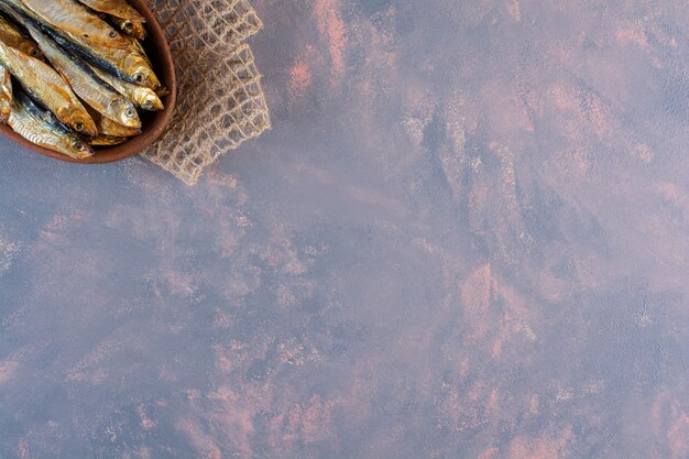 Sabroso pescado salado en una placa de madera sobre la superficie de mármol