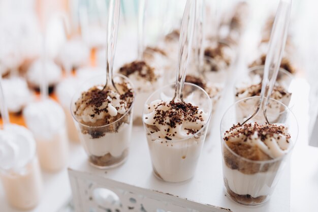 Foto gratuita sabroso postre de mousse con crema batida y chocolate en la mesa del banquete buffet