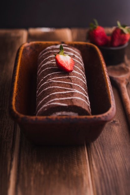 Foto gratuita sabroso rollo de chocolate con fresa en la parte superior