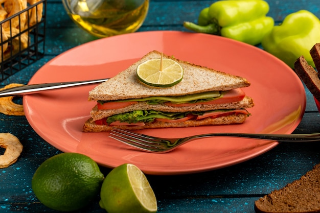 sabroso sándwich junto con aceite de pimientos verdes y limón sobre azul