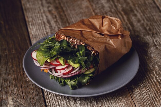 Sabroso sándwich vegano sobre mesa de madera