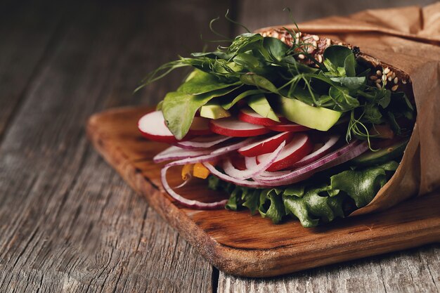 Sabroso sándwich vegano sobre mesa de madera