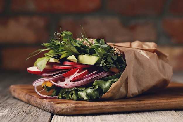 Sabroso sándwich vegano sobre mesa de madera