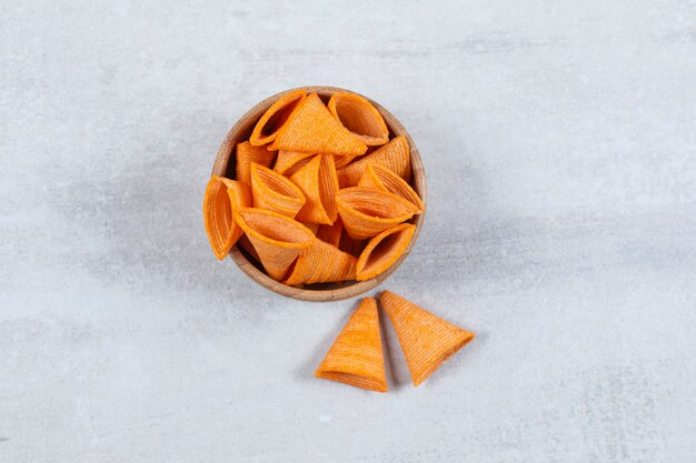 Sabrosos chips de triángulo en un tazón de madera.