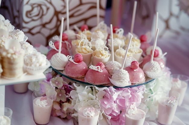 Sabrosos dulces rosados ​​y blancos servidos en un plato