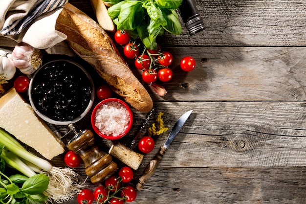 Sabrosos frescos apetitosos ingredientes de comida italiana para cocinar en antiguo fondo de madera rústica.