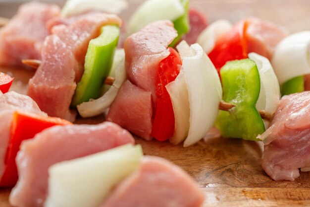 Sabrosos pinchos de carne cruda apetitosos sobre fondo de piedra oscura. De cerca