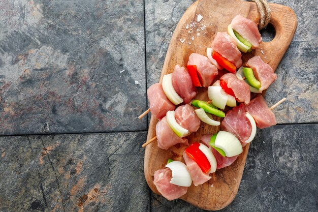 Sabrosos pinchos de carne cruda apetitosos sobre fondo vintage de madera. De cerca