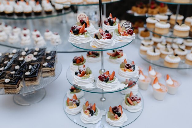 Sabrosos postres, pasteles y pasteles en el buffet dulce de la boda