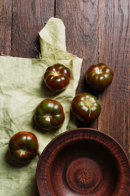 Sabrosos tomates frescos sobre fondo de madera y tela