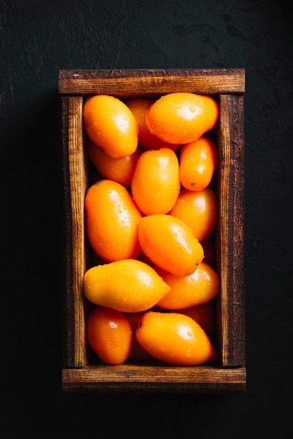 Sabrosos tomates naranjas en una vista superior de la cesta