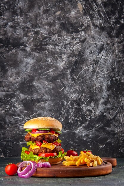 Sabrosos tomates sándwich caseros pimienta sobre tabla de cortar de madera cebollas tomate con tallo en la superficie de color oscuro