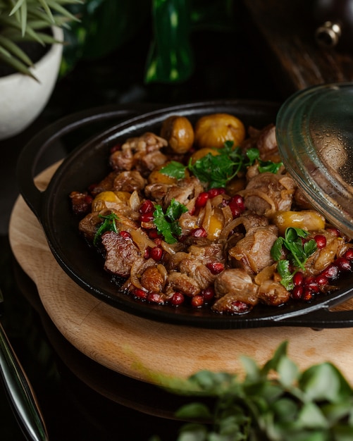 Sac qovurmasi, turshu govurma, comida local dentro del saco negro con hierbas