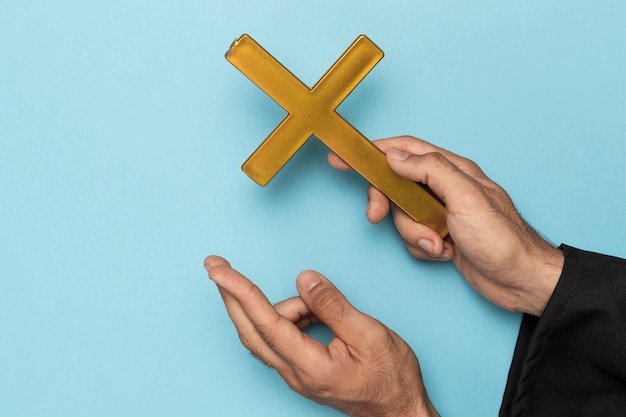 Sacerdote con cruz de dedo y cruz de madera