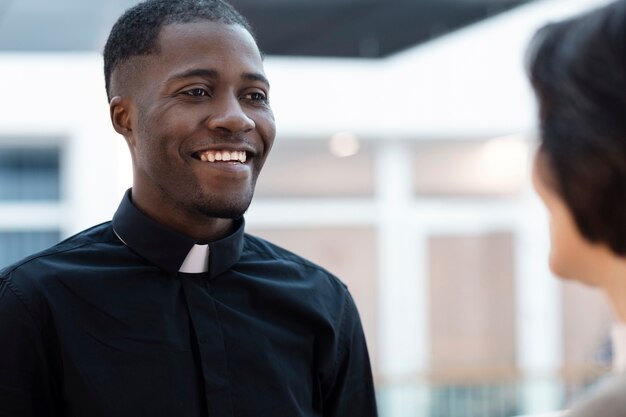 Sacerdote joven que se encuentra con una mujer para recibir dirección espiritual