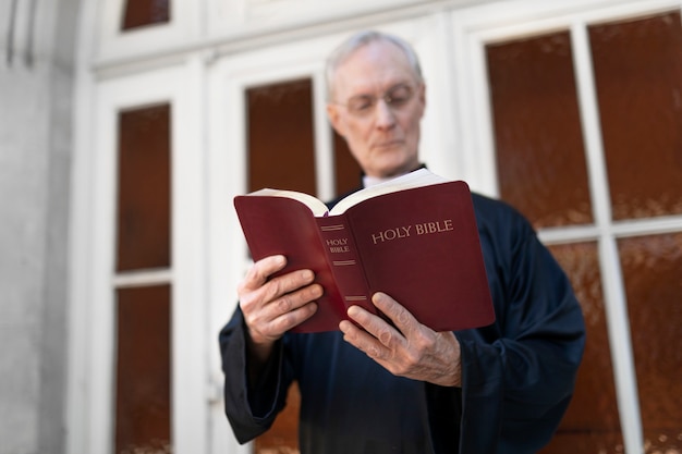 Foto gratuita sacerdote leyendo de la biblia