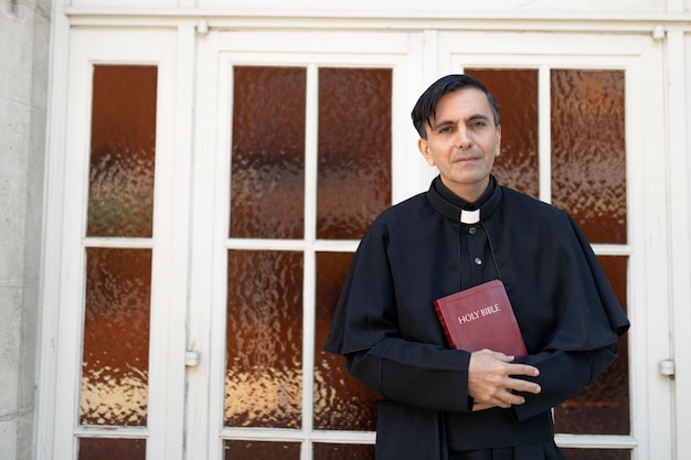 Foto gratuita sacerdote leyendo de la biblia