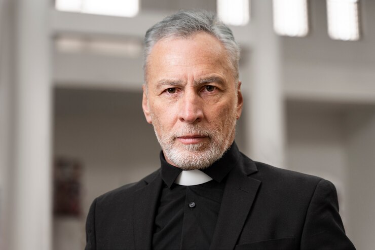 Foto gratuito sacerdote mayor en la iglesia con traje