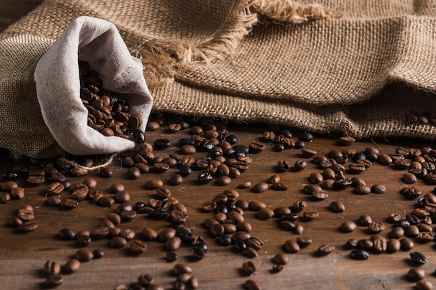 Saco con granos de café en mesa.