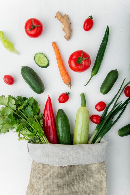 saco lleno de verduras en mesa blanca