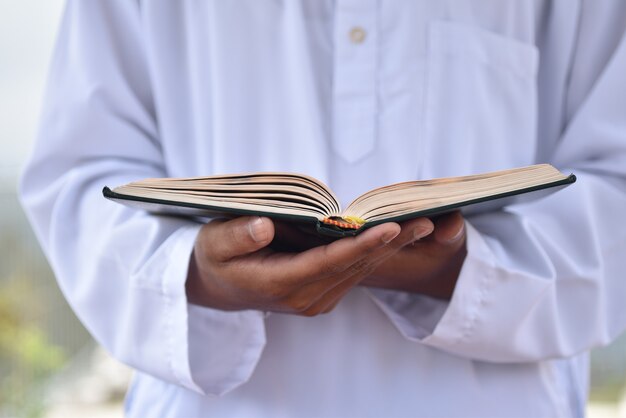 Sagrado Corán en la mano con el significado de la caligrafía árabe de Al Quran.