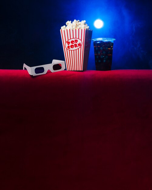 Sala de cine con paquete de palomitas y gafas 3d