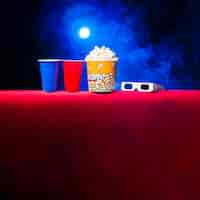 Foto gratuita sala de cine con paquete de palomitas y gafas 3d