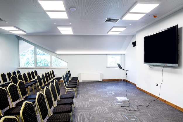 Sala de conferencias asientos vacíos en fila y pantalla de proyección antes de un seminario