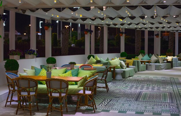 Una sala de restaurante con muebles de colores vivos y ventanas panorámicas.