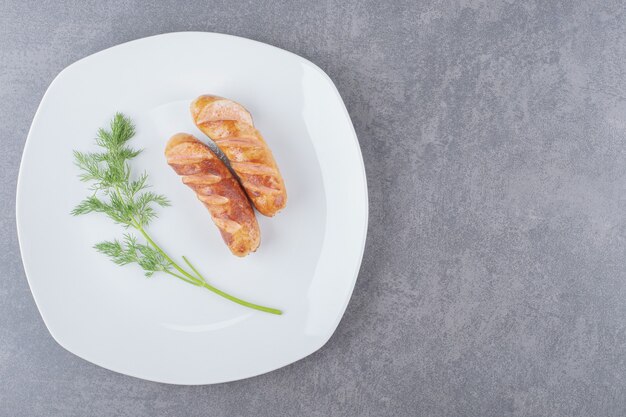 Salchichas fritas en un plato blanco