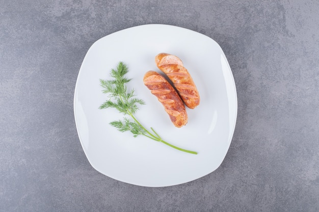 Salchichas fritas en un plato blanco