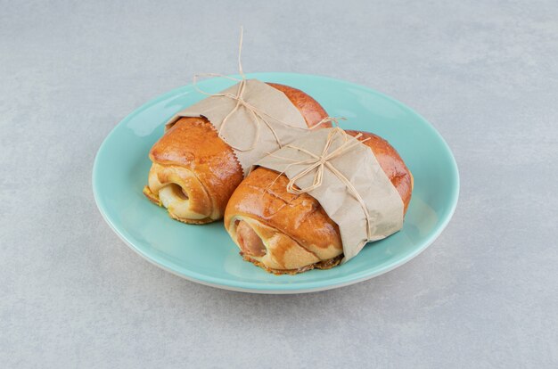 Salchichas de pastelería deliciosas en placa azul.