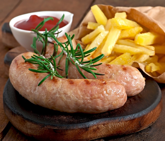 Salchichas de pollo a la parrilla con guarnición de papas fritas