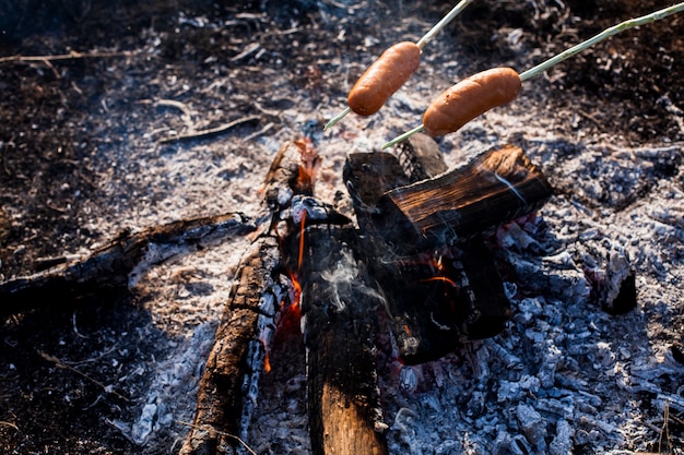 Salchichas preparándose para comer sobre fuego